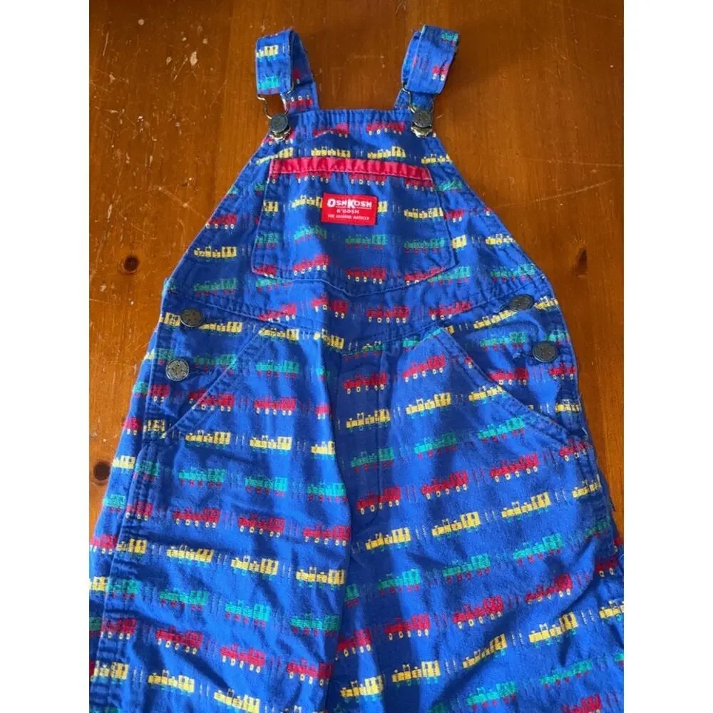 OshKosh B'gosh Bright Blue Overalls with Red, Yellow and Green Train Print